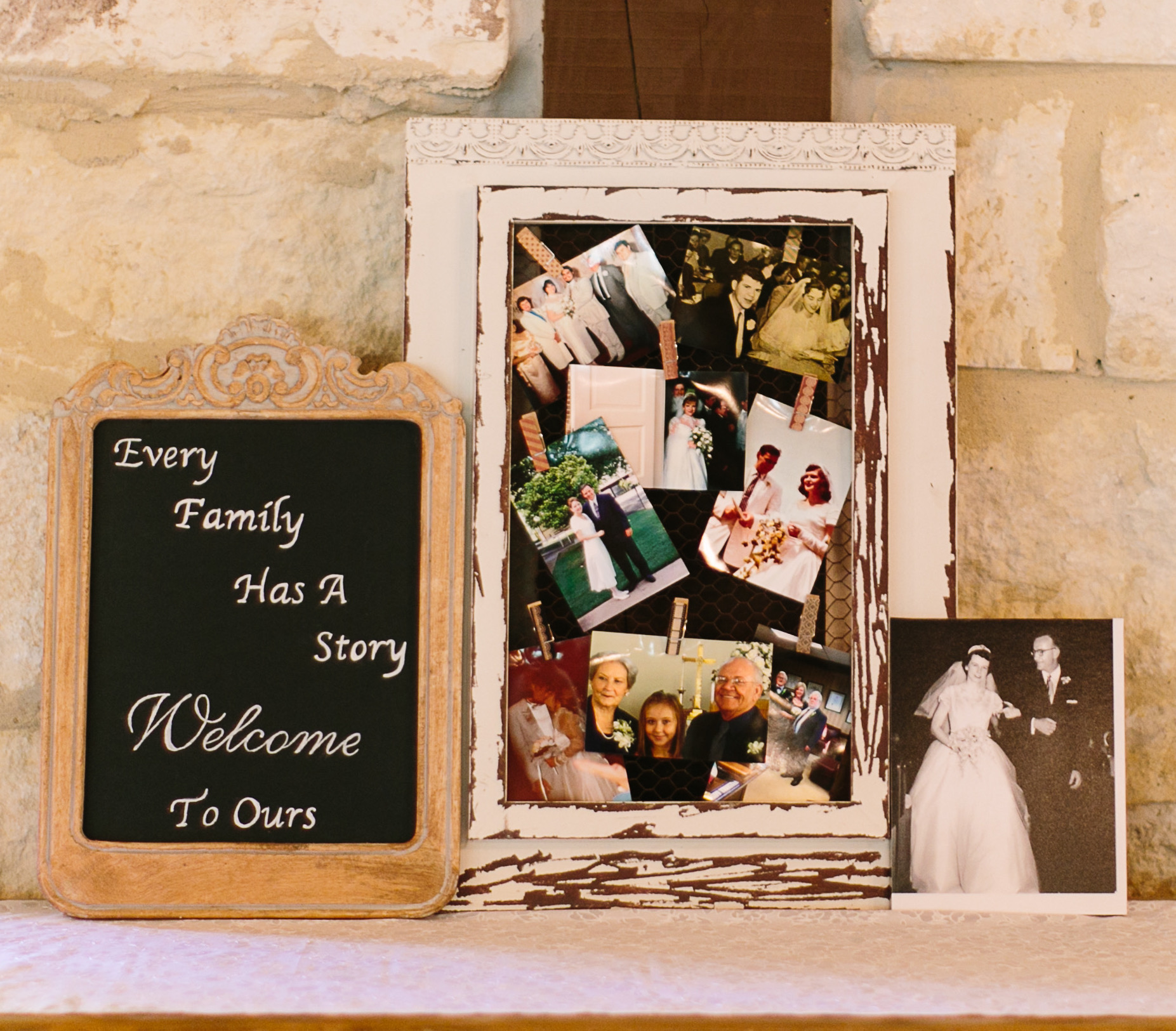 A chalkboard and a collection of past wedding photos displayed on a table 