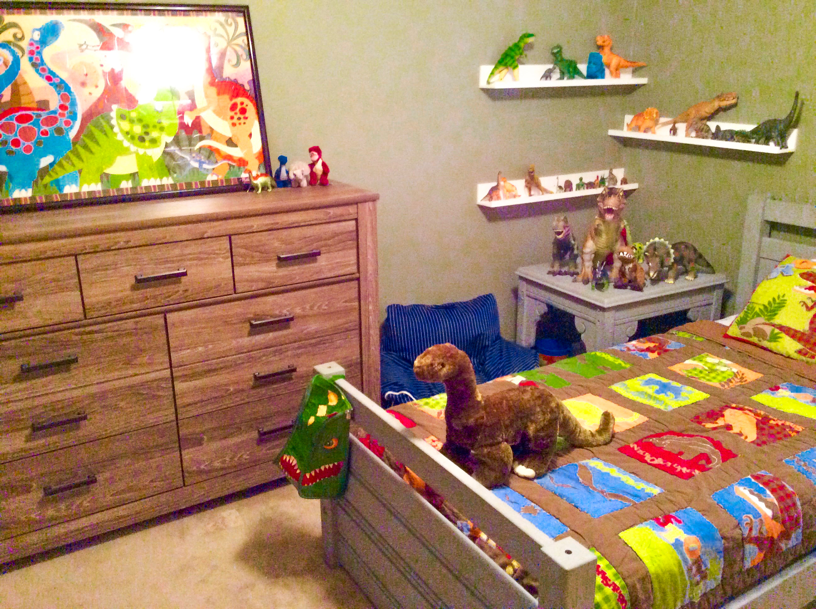 A colorful dinosaur themed room with camo green walls
