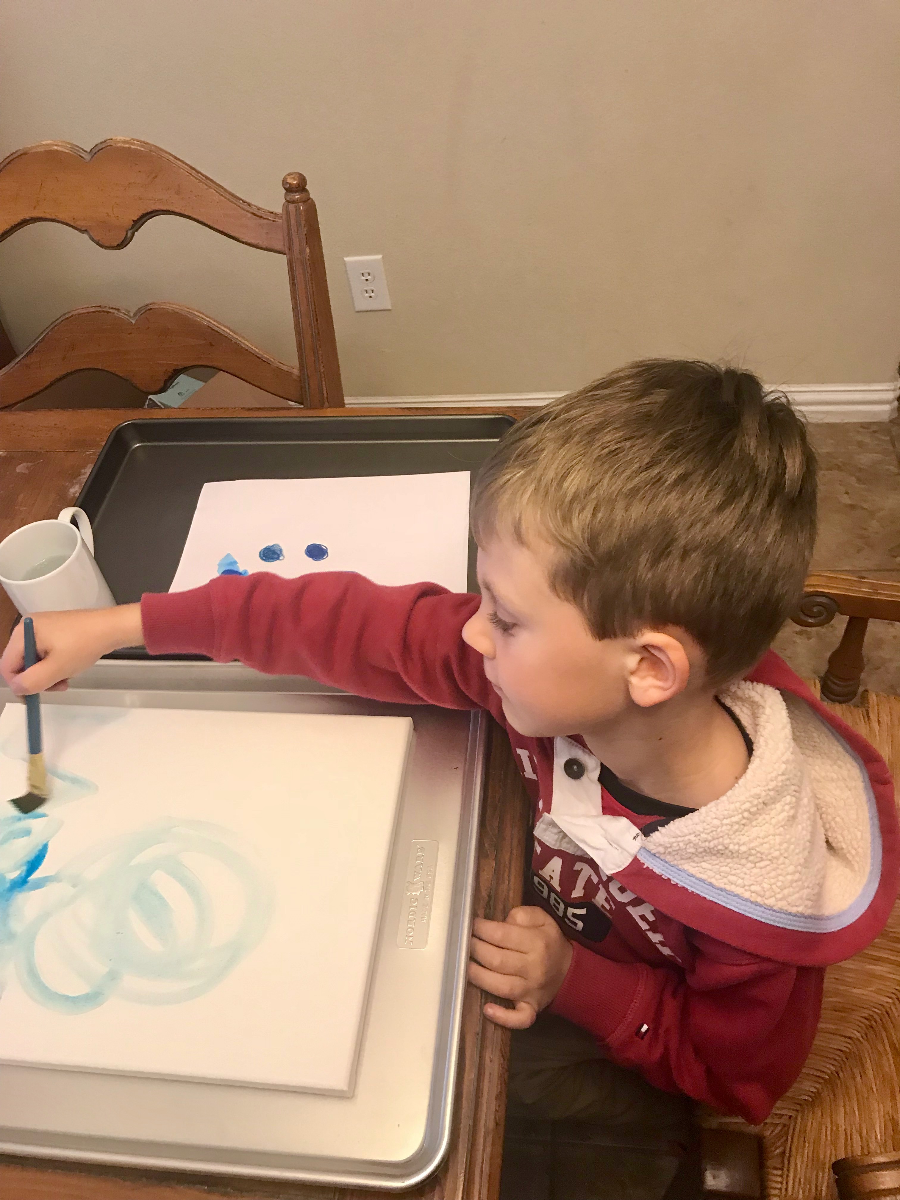 Child painting canvas blue