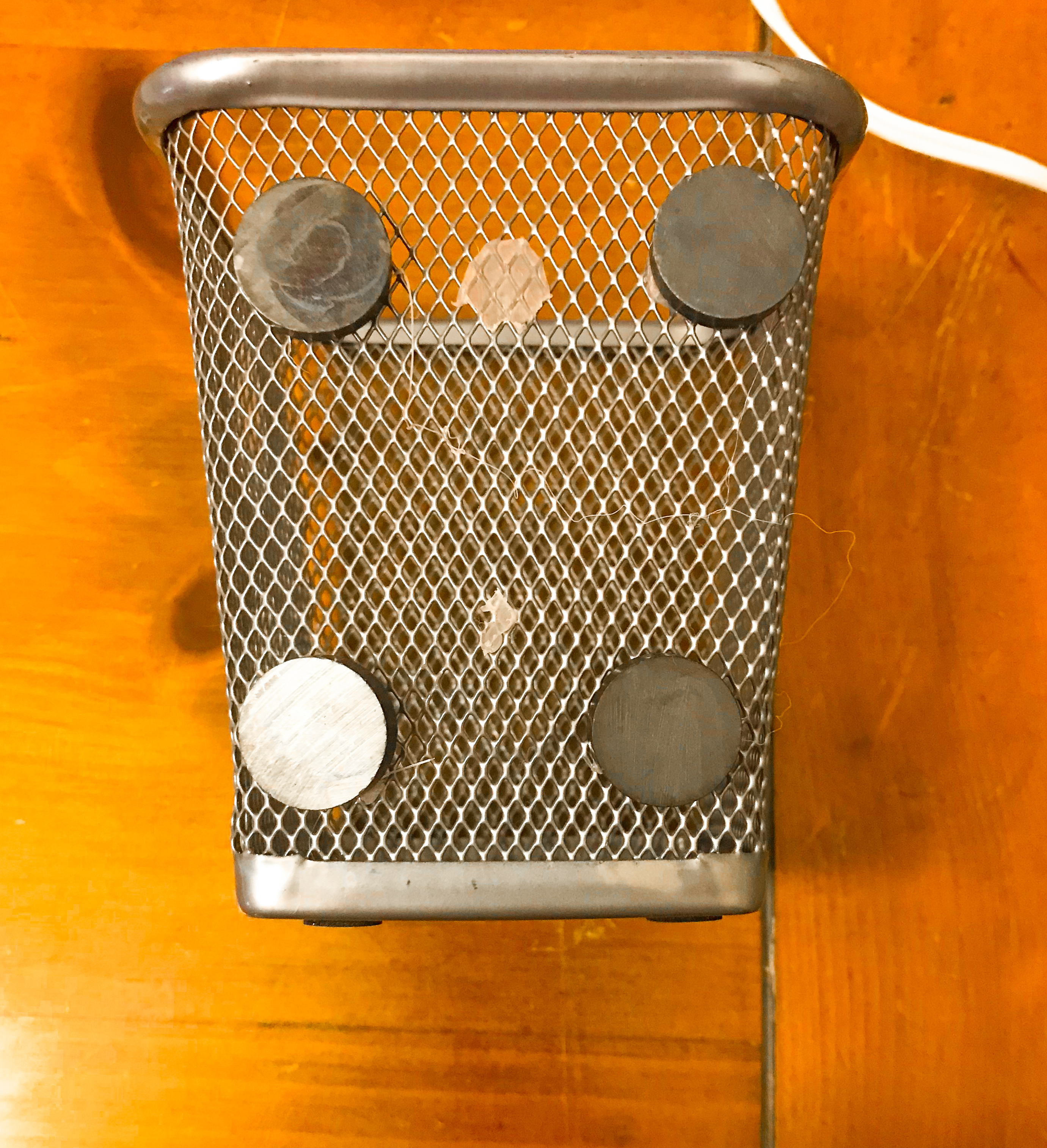 A metal pencil holder with 4 disc magnets glued to the back.