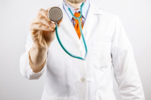 Doctor in white coat holding a stethoscope 