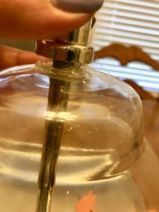 Fingers lifting top of fillable lamp to show gap. 