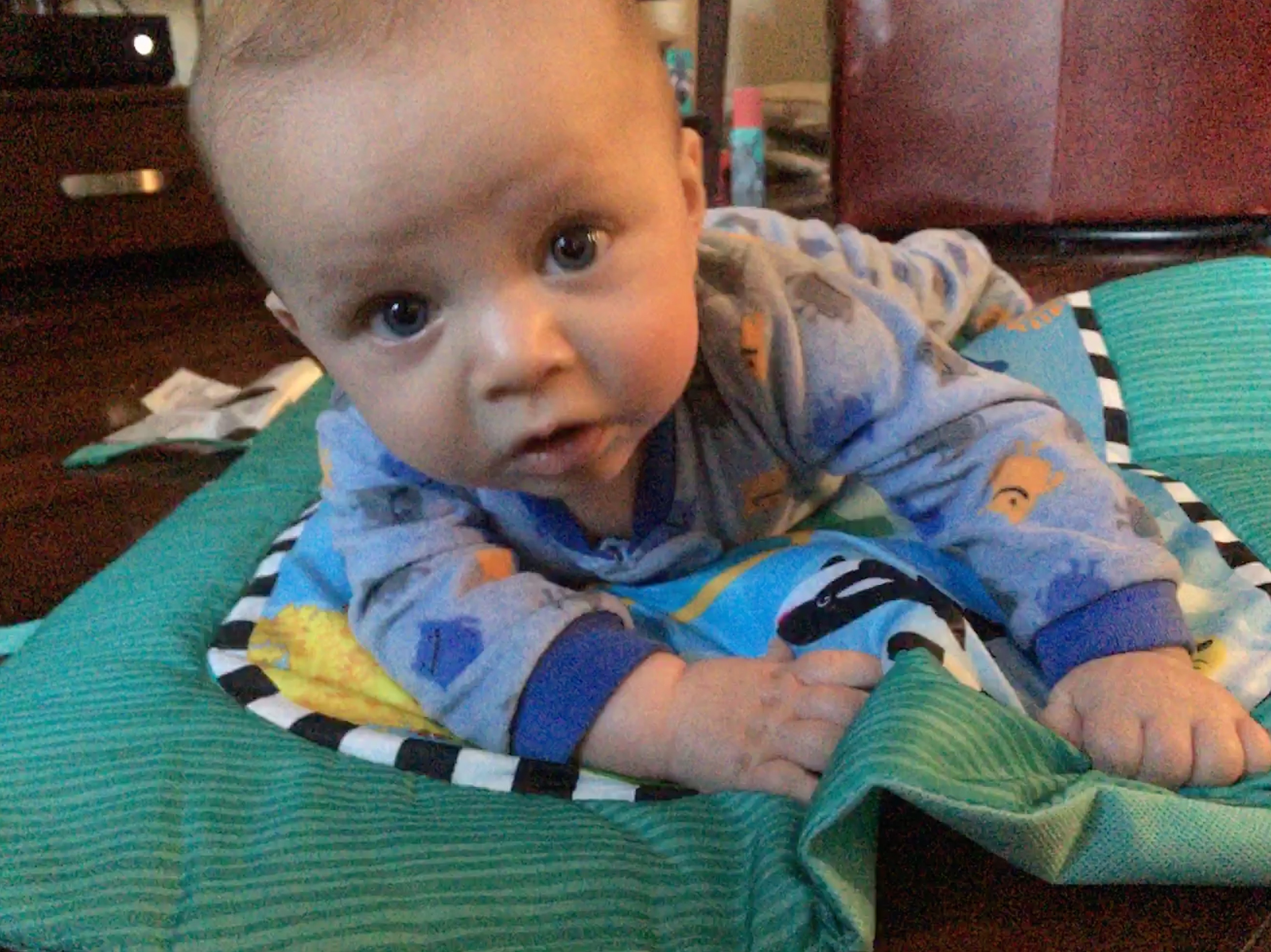 A baby doing tummy time on an activity mat 