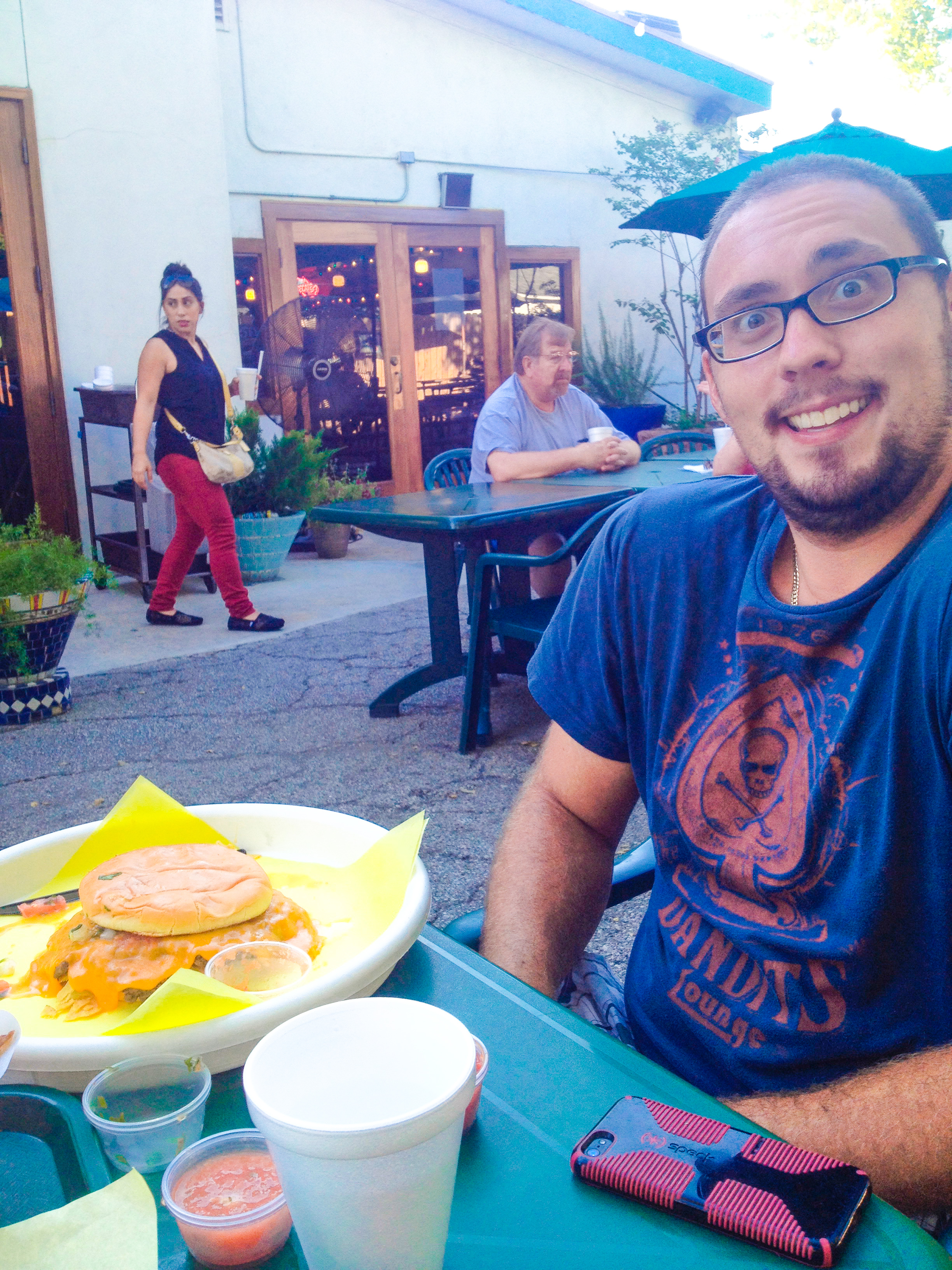 A Person eating a Tosatada burger at Chris Madrid's.