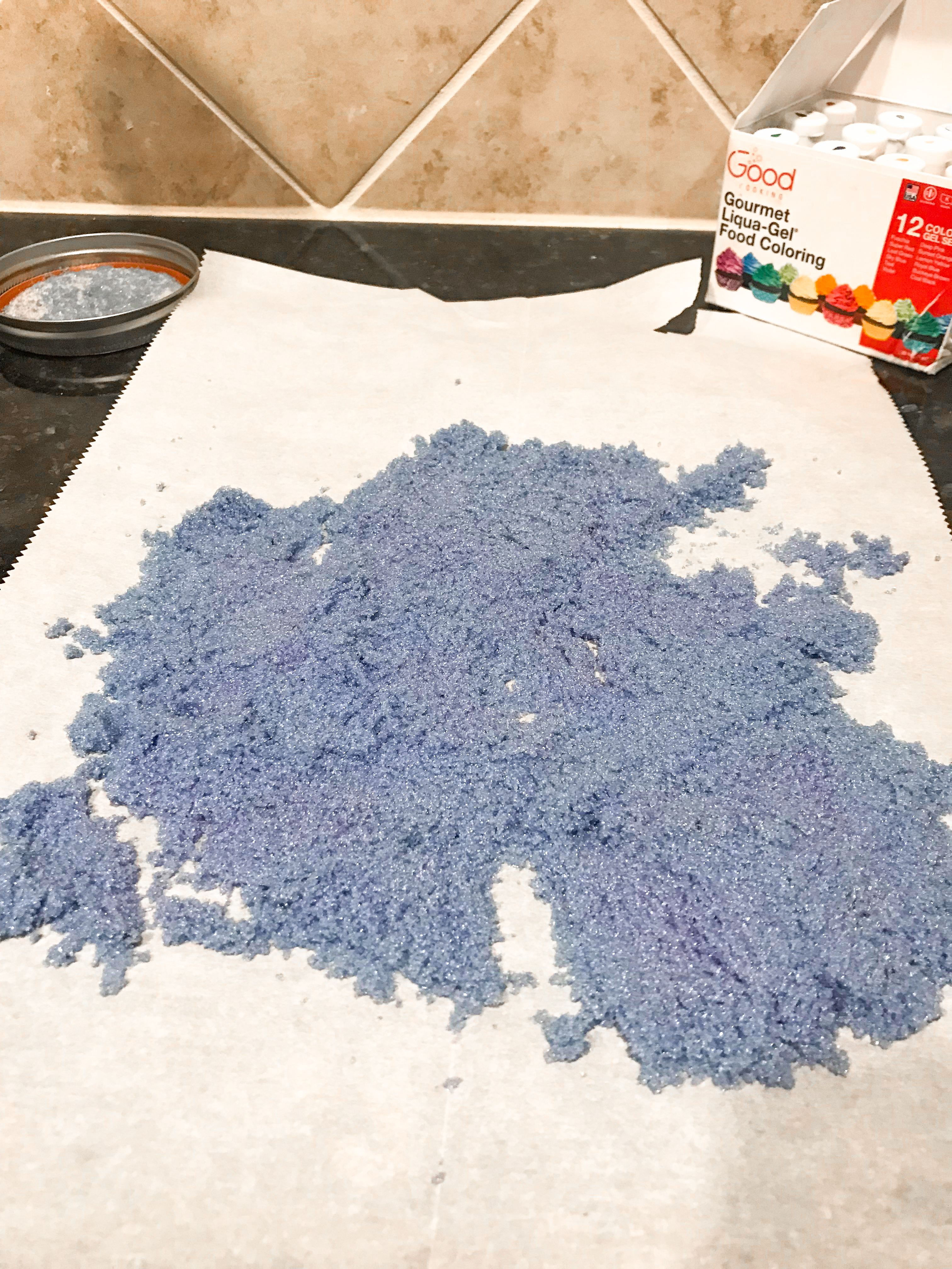 Vibrant purple sugar spread in a layer on parchment paper. 