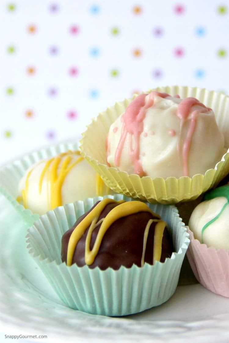 Various pastel truffles in front of a colorful background. 