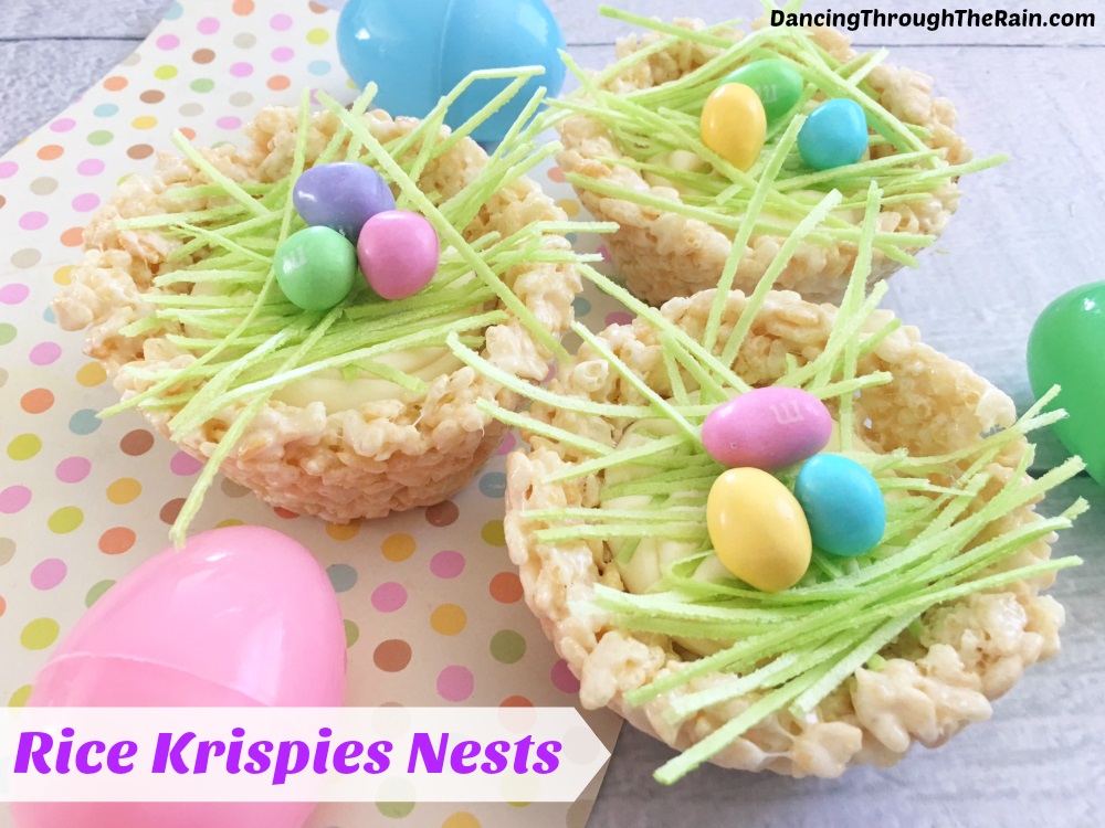 Rice krispie nests with green grass and candy on top of a colorful paper background. 