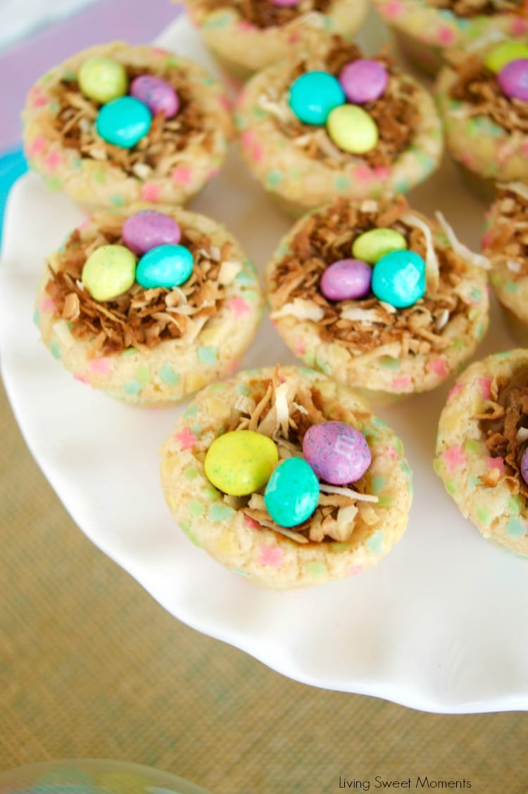 Cookie nests containing coconut and candies on top of a white platter