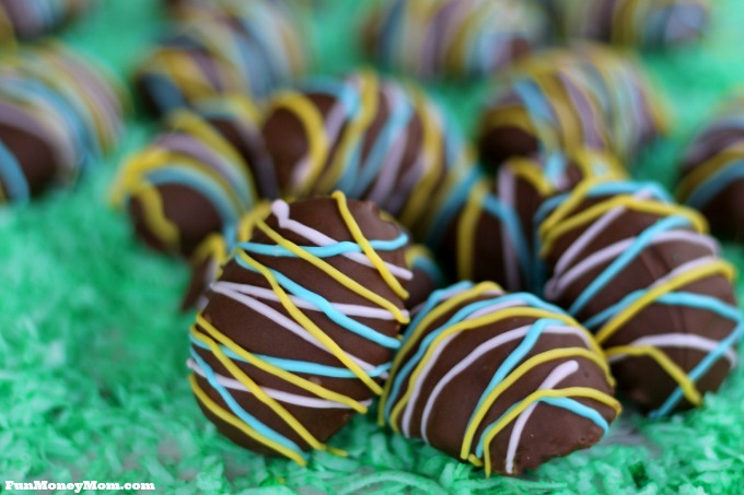 Chocolate covered eggs with a pastel drizzle on a green background