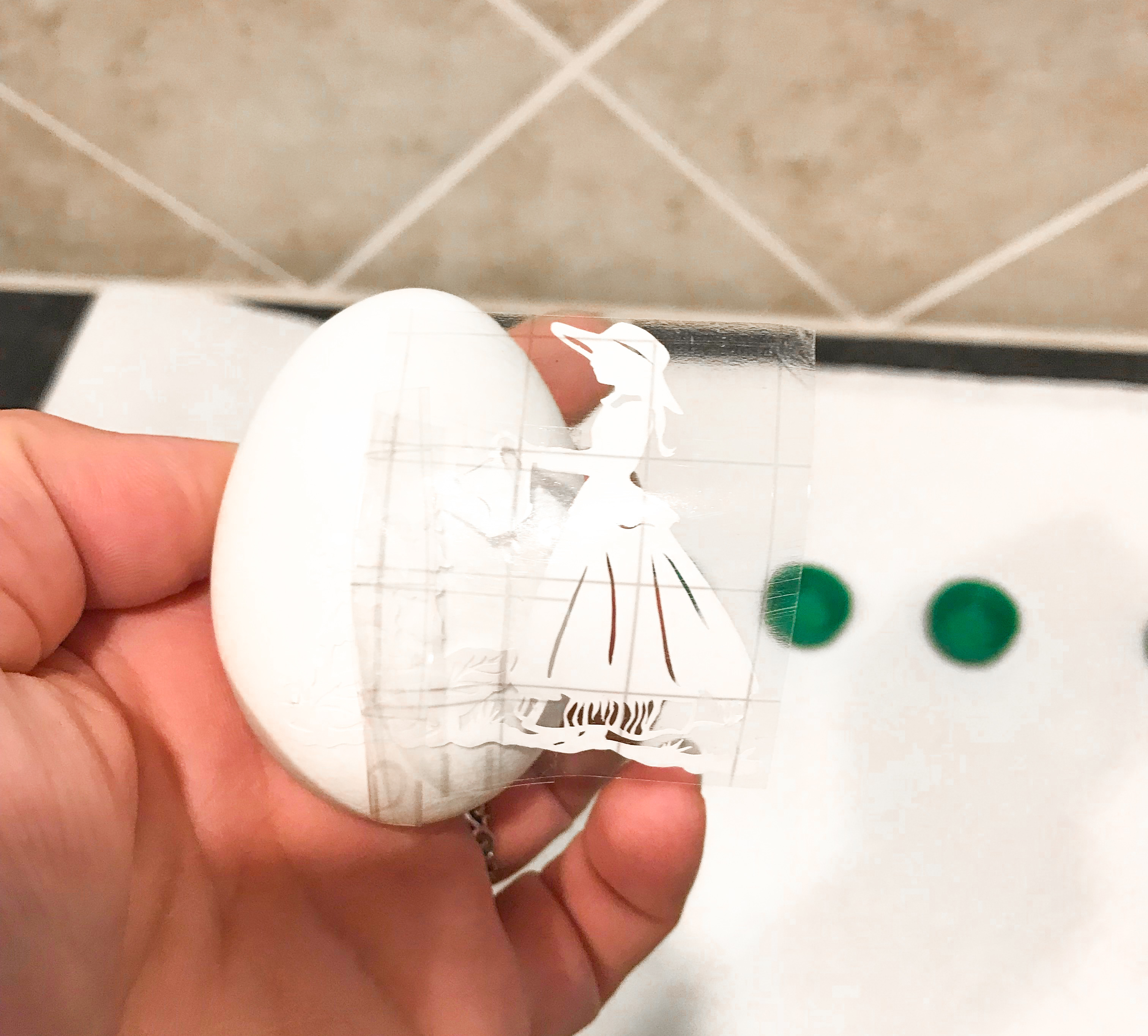 Transfer tape being peeled off of an Easter egg. 
