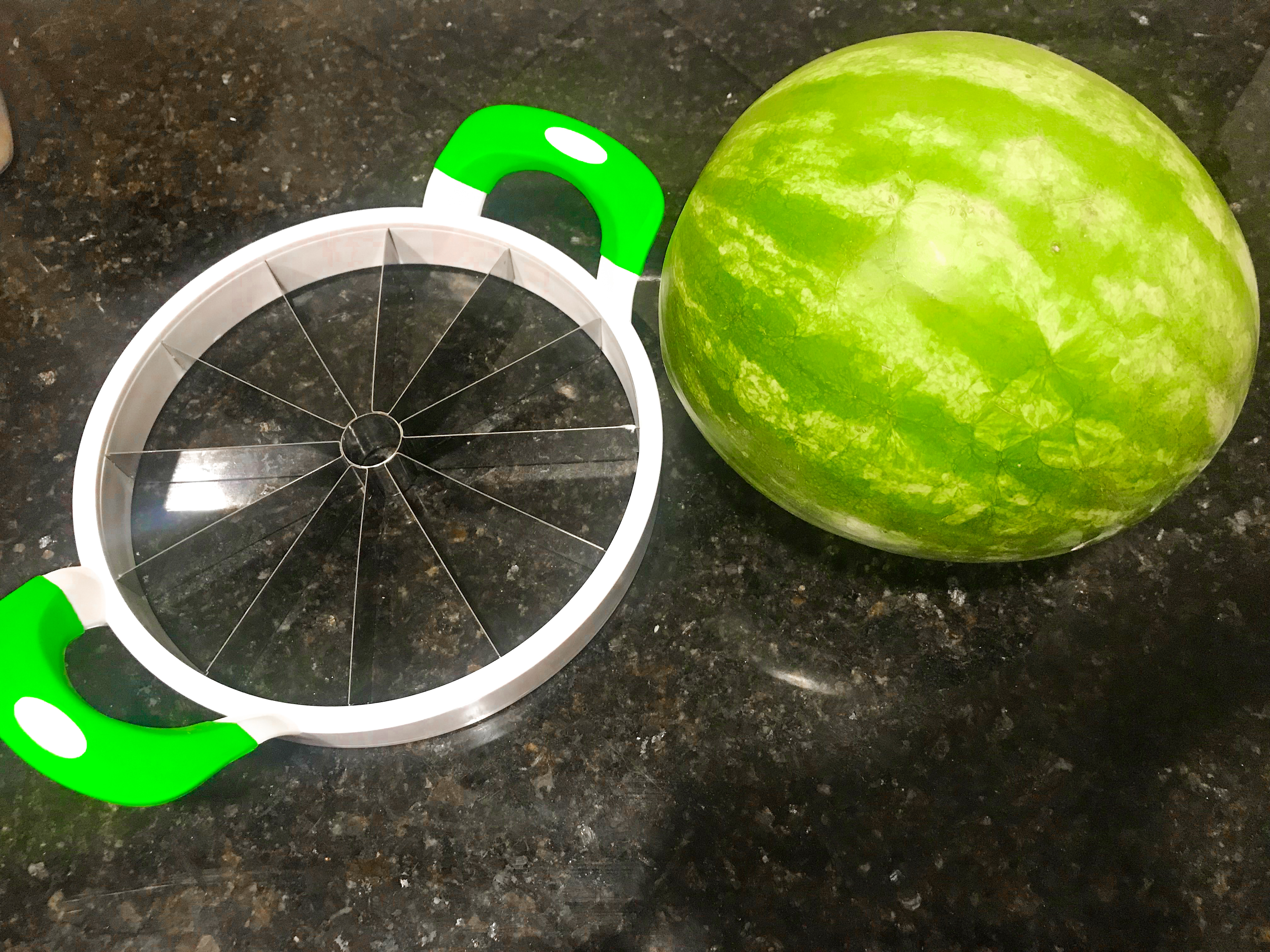 A watermelon and a watermelon slicer. 