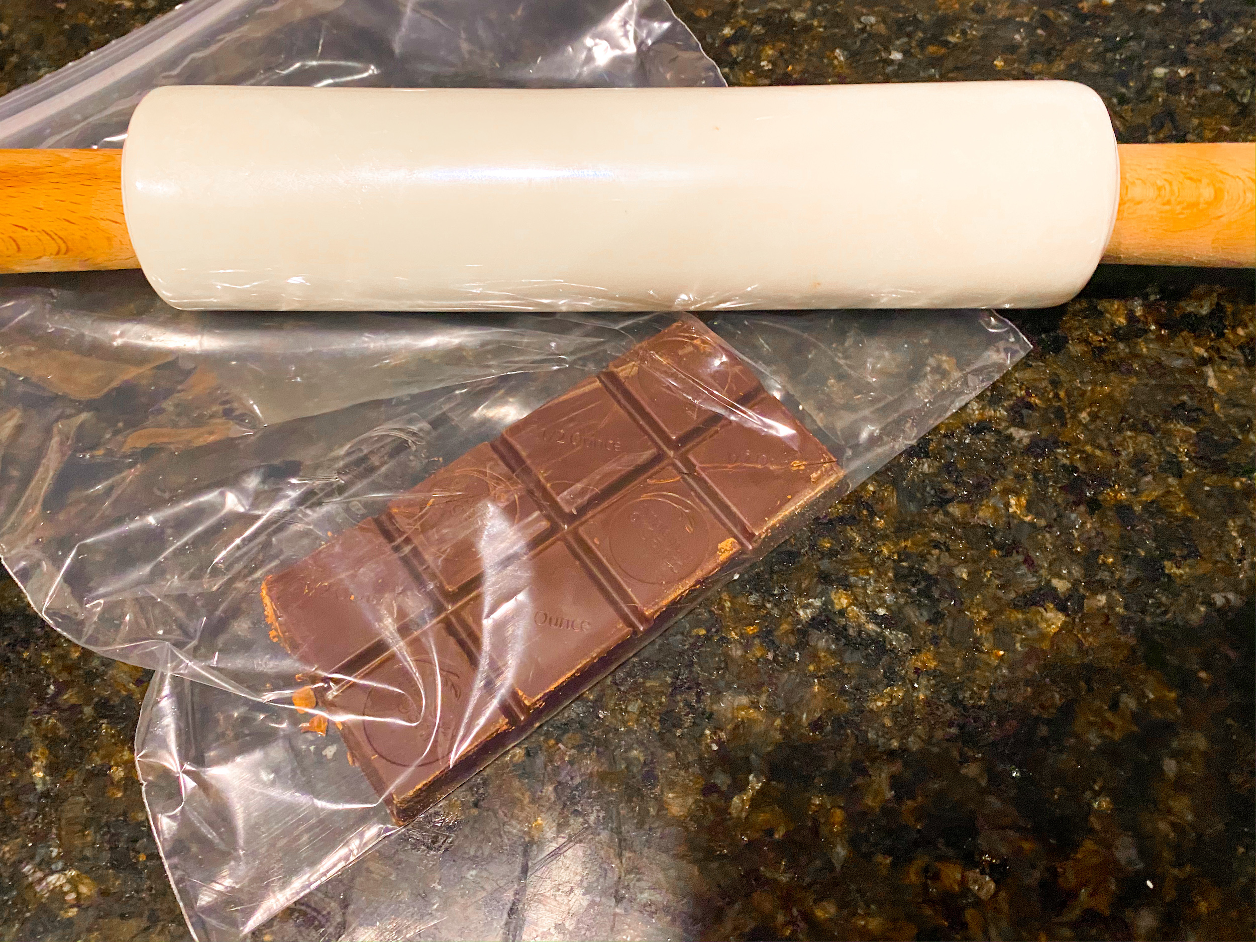 A semi sweet chocolate bar in a bag with a rolling pin. 