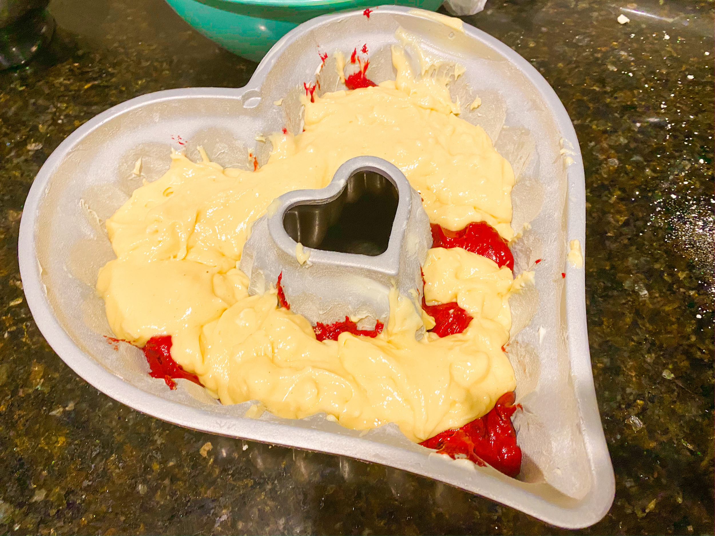 Layered red velvet and yellow bundt cake mix in a heart shaped bundt cake pan. 