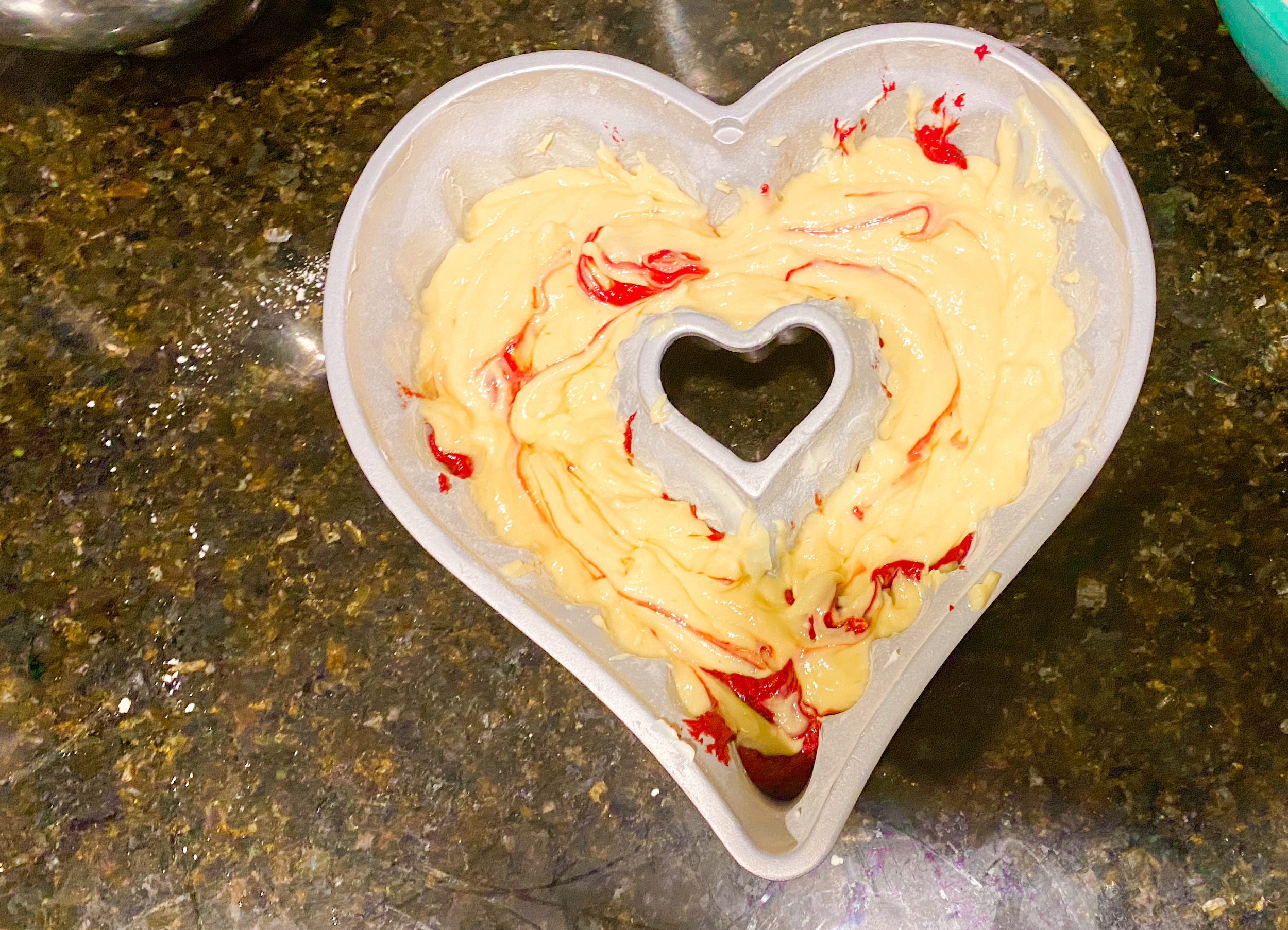 Swirled bundt cake mix in a heart shaped pan.