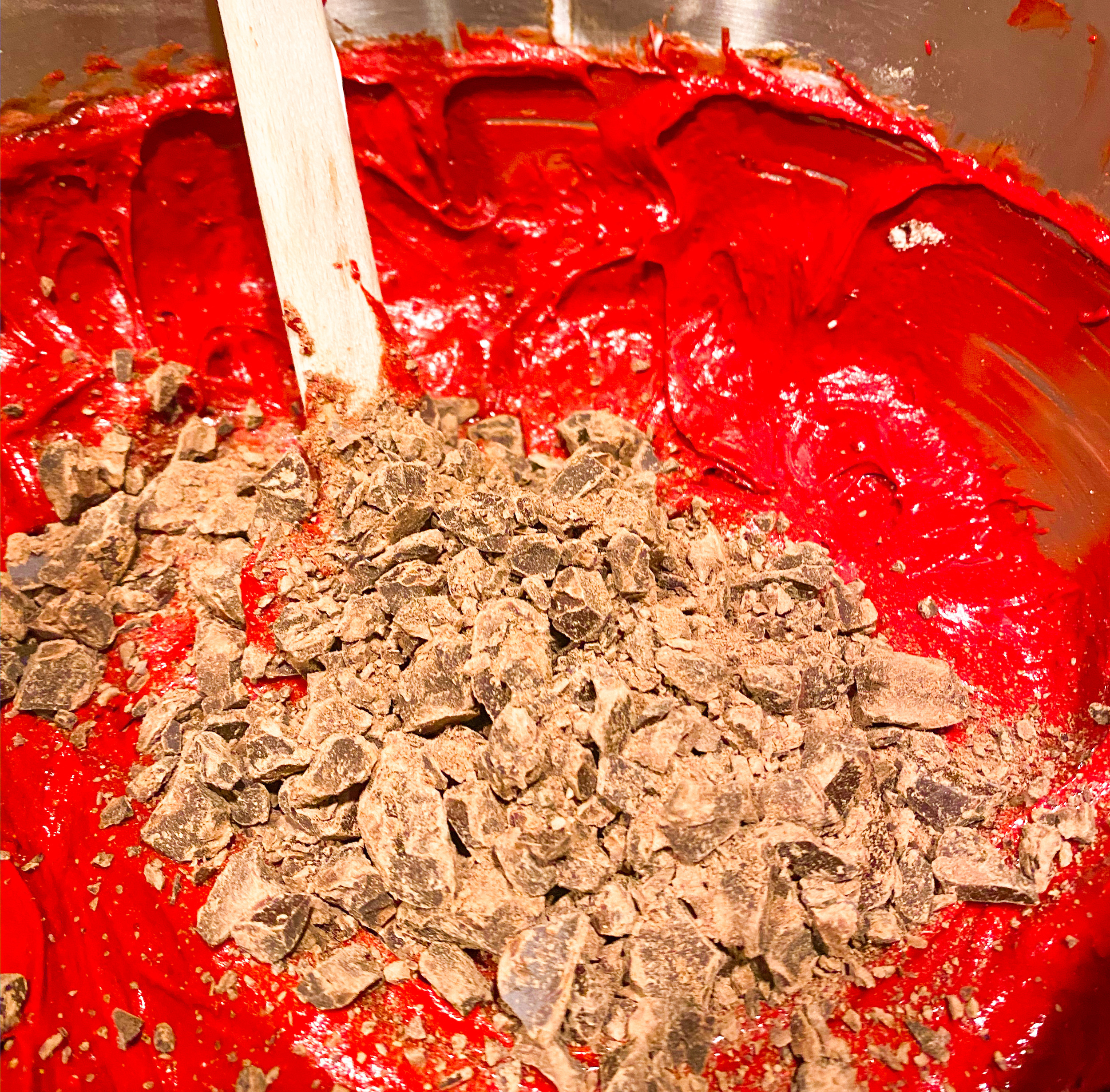 Adding crushed semi sweet chocolate to red velvet bundt cake mix. 